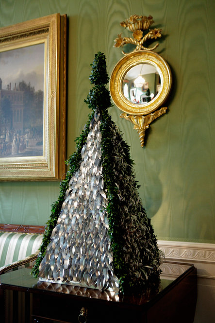Some of the handcrafted decorations are made of paper, felt and recycled cans, like these handcrafted tabletop trees in the Green Room. 