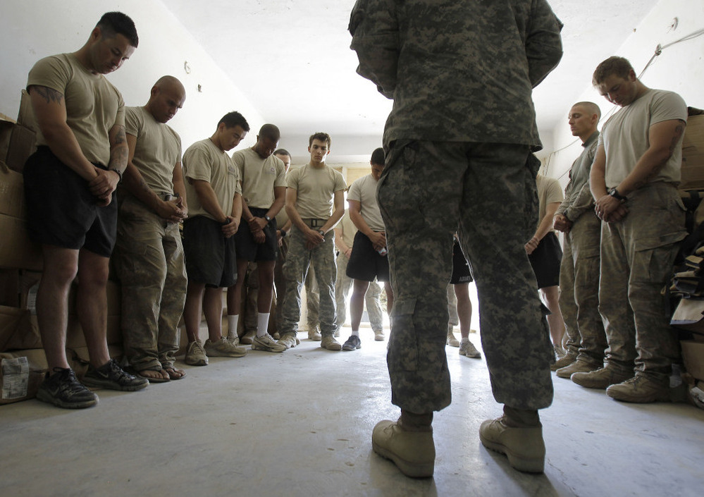 Soldiers pray with a chaplain in Afghanistan. Jason Torpy says military chaplains are assigned many secular advising duties that atheist service members need, too.