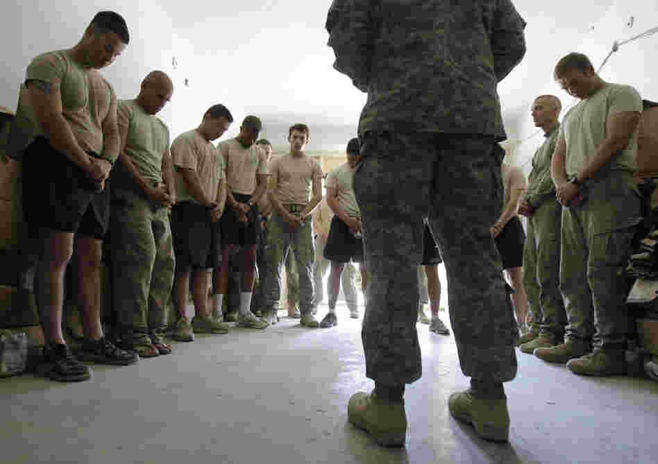 Soldiers pray with a chaplain in Afghanistan. Jason Torpy says military chaplains are assigned many secular advising duties that atheist service members need, too.