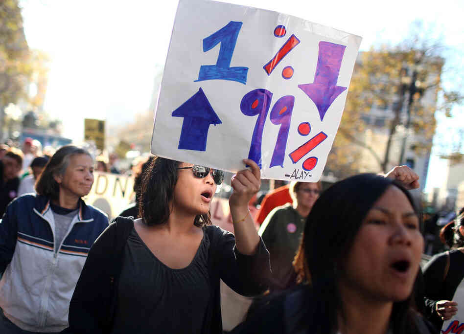A protestor carries a sign as she marches down Market Street during a day of action in support of the Occupy Wall Street movement on Dec. 2 in San Francisco.