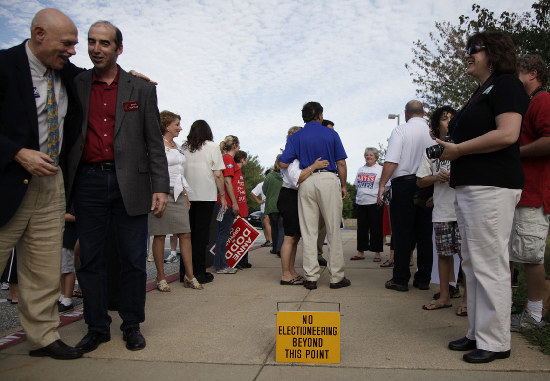 Former Maryland Gov. Bob Ehrlich (center, in the blue shirt) greets voters outside a polling place in Ellicott City, Md., in 2010. Ehrlich campaign manager Paul Schurick is now facing charges for allegedly discouraging voters from going to the polls on Election Day.