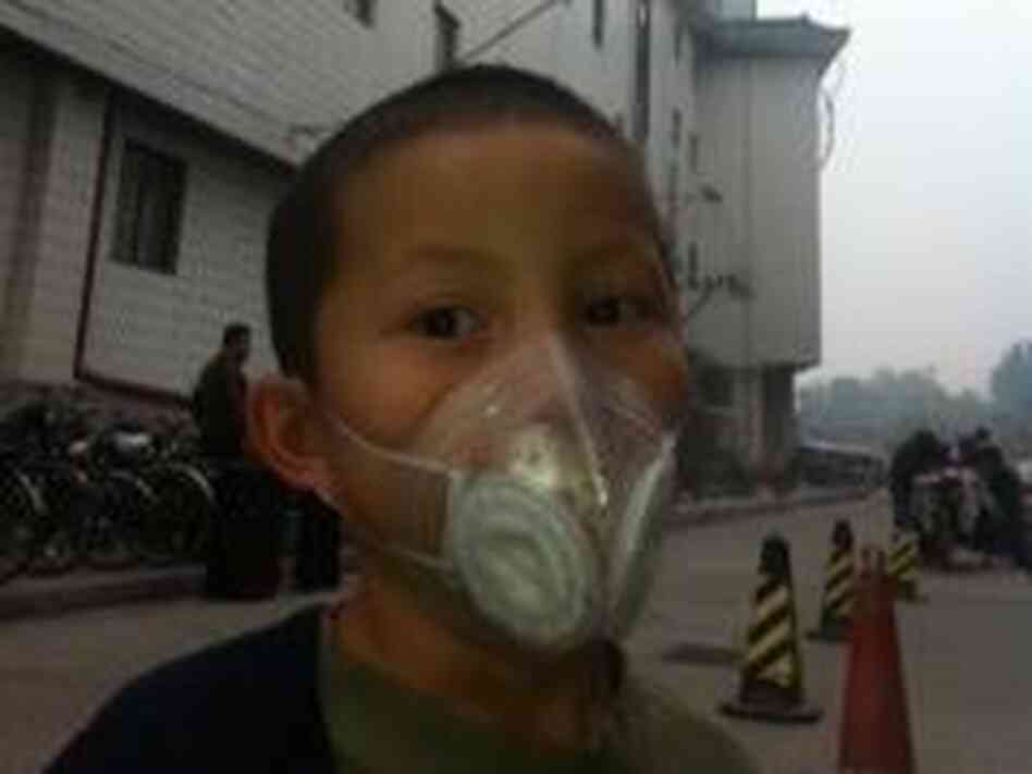 On a recent day, NPR correspondent Louisa Lim's 6-year-old son, Daniel, wears a protective mask outside. On a recent day, NPR correspondent Louisa Lim's 6-year-old son, Daniel, wears a protective mask outside.