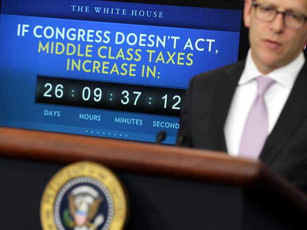 White House press secretary Jay Carney speaks Monday during his daily press briefing, as a clock counting down the expiration of the payroll tax cut benefit looms in the background. 