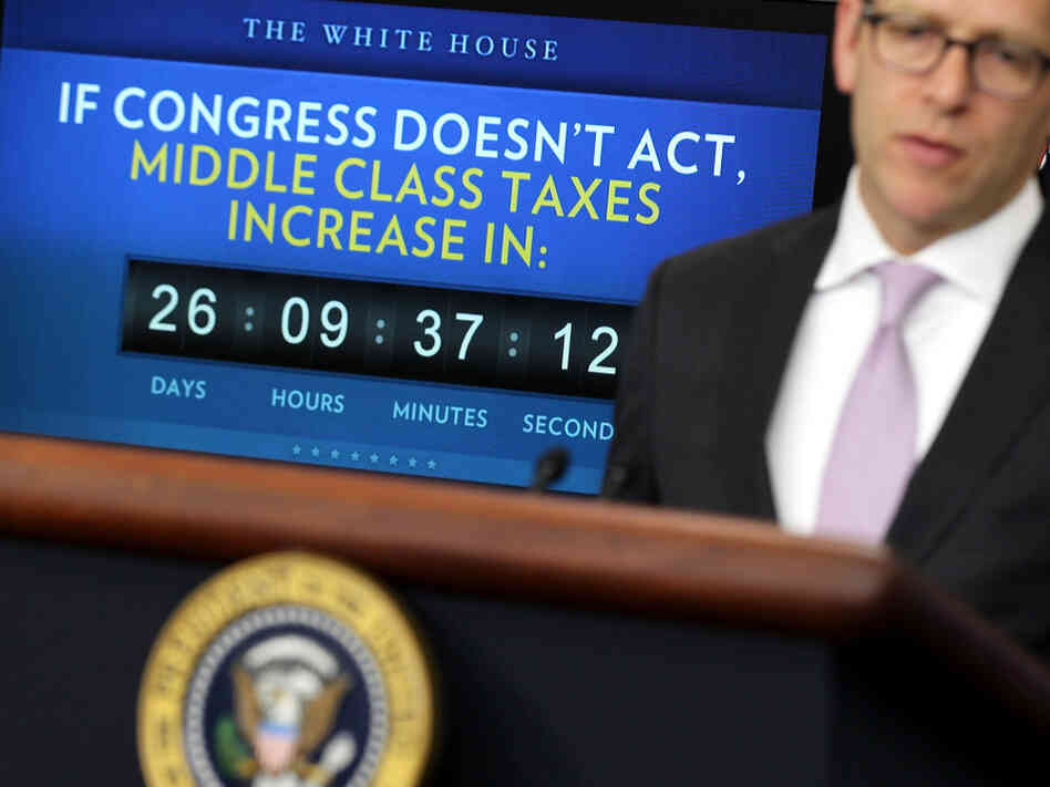 White House press secretary Jay Carney speaks Monday during his daily press briefing, as a clock counting down the expiration of the payroll tax cut benefit looms in the background. 
