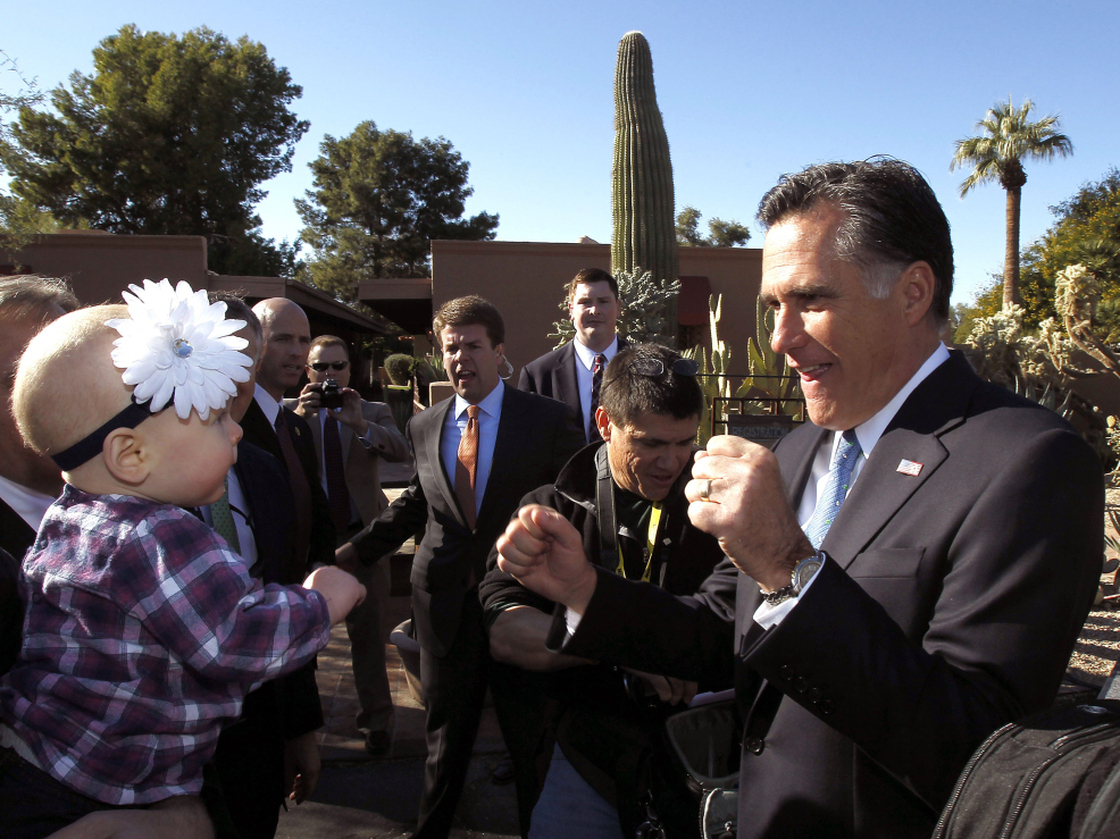 Mitt Romney entertains a toddler in Paradise Valley, AZ, Tuesday, Dec. 6, 2011.
