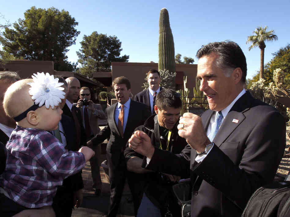 Mitt Romney entertains a toddler in Paradise Valley, AZ, Tuesday, Dec. 6, 2011.