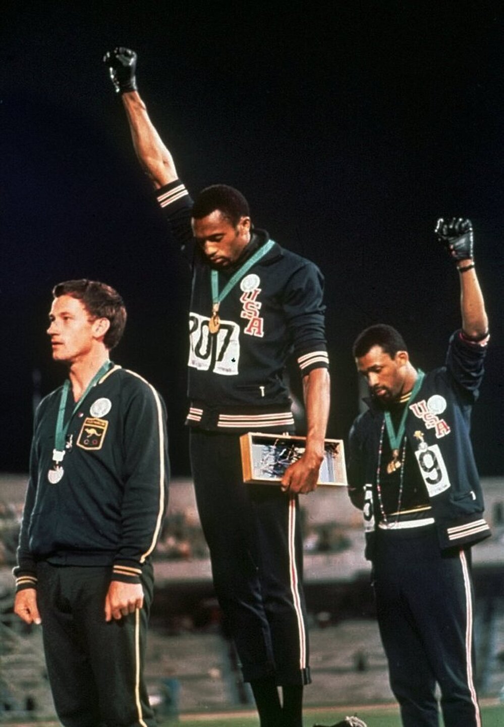 In this Oct. 16, 1968 photo, extending gloved hands skyward, U.S. athletes Tommie Smith (center) and John Carlos (right) stare downward during the playing of the "Star-Spangled Banner" at the Summer Olympic Games in Mexico City.