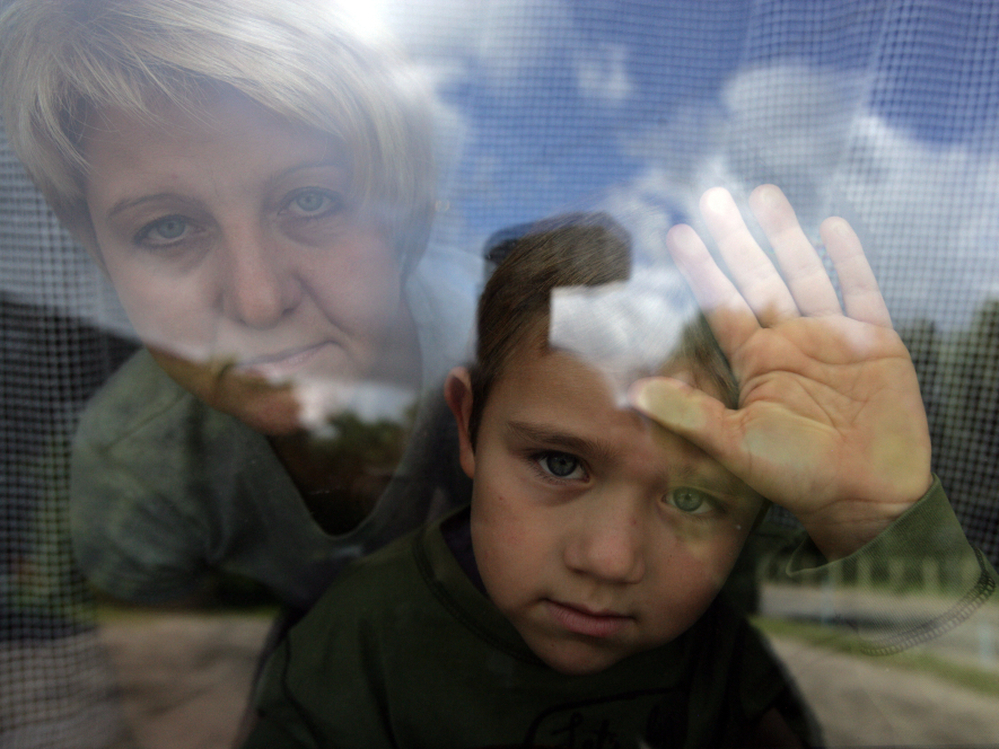 Janina Wasilewski, 41, and Brian, 6, look out one of their few windows in their tiny Polish apartment on Wednesday, Sept. 19, 2007 in Nowe Miasto Lubaswskie.