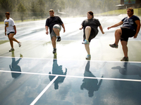 Wellspring students do high steps on the tennis court. Exercise is paramount at Wellspring, and a little rain doesn't get in the way of outdoor activities.