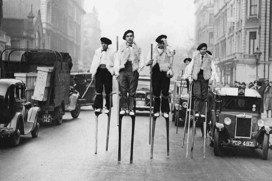French stilt dancers from Landes, in southwestern France, walk through London on their way to the 1937 Silver Jubilee Festival of the English Folk Dance and Song Society. 