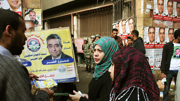 A campaigner for the Muslim Brotherhood's Freedom and Justice Party talks to voters in front of a polling station in Cairo on Nov. 28.