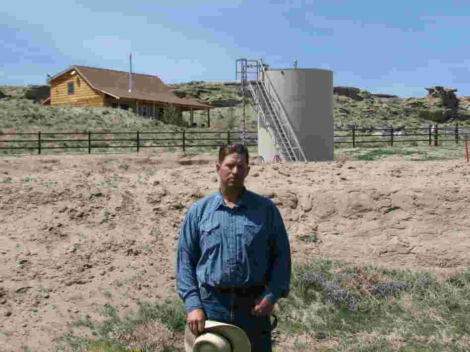 This May 2009 picture shows John Fenton, a farmer who lives near Pavillion in central Wyoming, standing near a tank used in natural gas extraction. Fenton and some of his neighbors blame fracking for fouling their well water. 