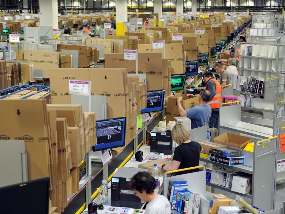 Employees pack goods at a logistics center in Bad Hersfeld, Germany.