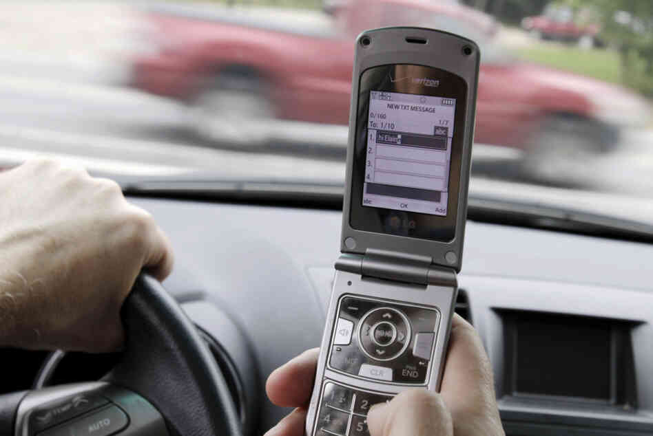 FILE - In this Sept. 20, 2011 file photo, a phone is held in a car in Brunswick, Maine. Texting while driving increased 50 percent last year and two out of 10 drivers say they've sent text messages or emails while behind the wheel despite a rush by states to ban the practice, the National Traffic Safety Administration said Thursday. (AP Photo/Pat Wellenbach, File)