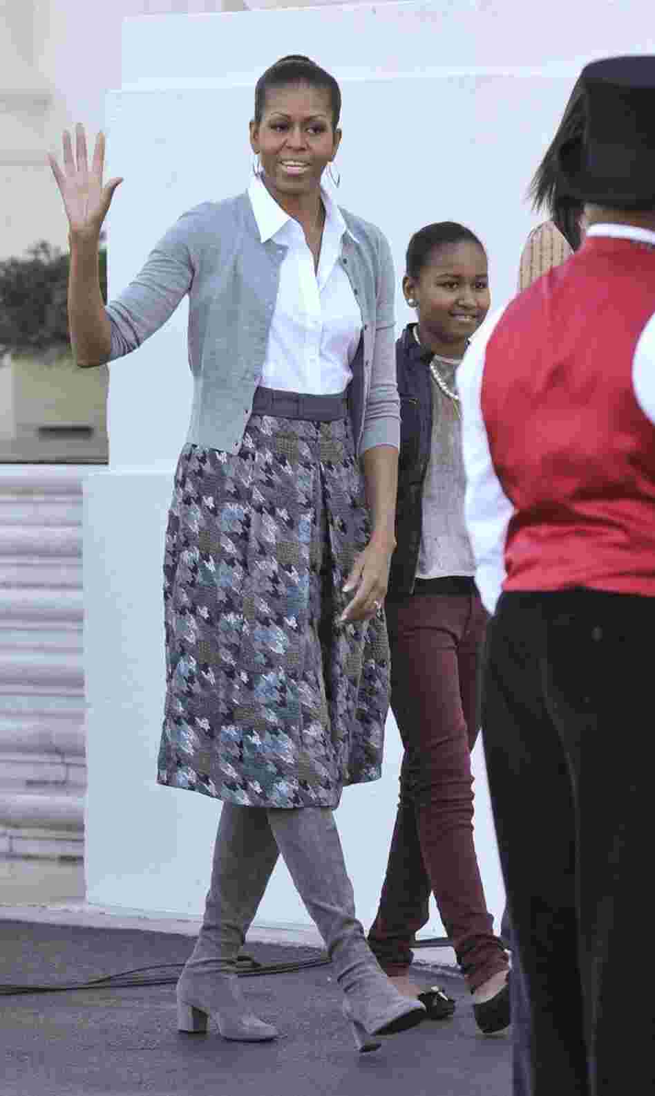 Michelle Obama shows off a gray outfit with a simple cardigan and a houndstooth skirt.