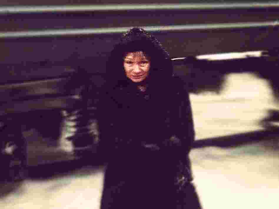 A woman is bundled up by the tracks of the Trans-Siberian railway.