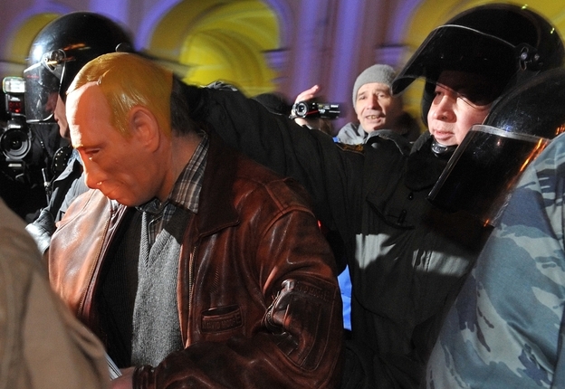 Riot police officers detain a man in a mask depicting Russia's Prime Minister Vladimir Putin during an opposition protest in St. Petersburg on Thursday.