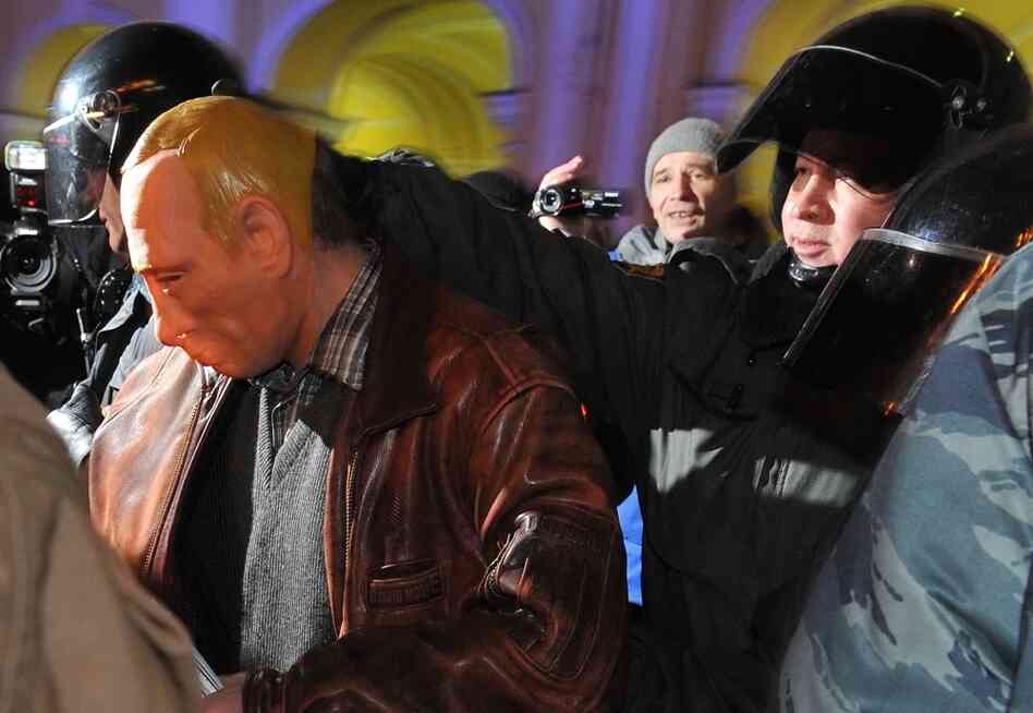 Riot police officers detain a man in a mask depicting Russia's Prime Minister Vladimir Putin during an opposition protest in St. Petersburg on Thursday.