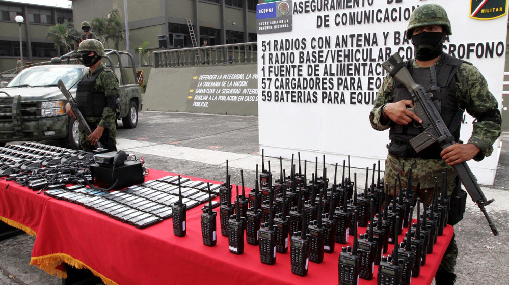 Mexican soldiers stand guard behind communication radios seized from alleged drug cartel members in Veracruz, Mexico, Nov. 23. 