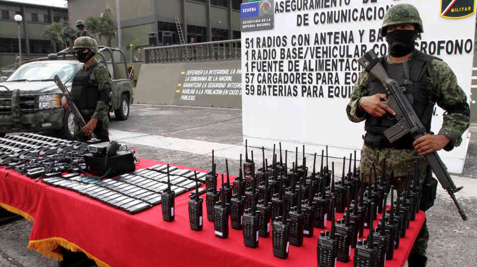 Mexican soldiers stand guard behind communication radios seized from alleged drug cartel members in Veracruz, Mexico, Nov. 23. 