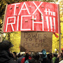Protesters fill the street and carry signs across from the Occupy Portland camp in Portland, Ore., holding a sign that demands "Tax the rich!"