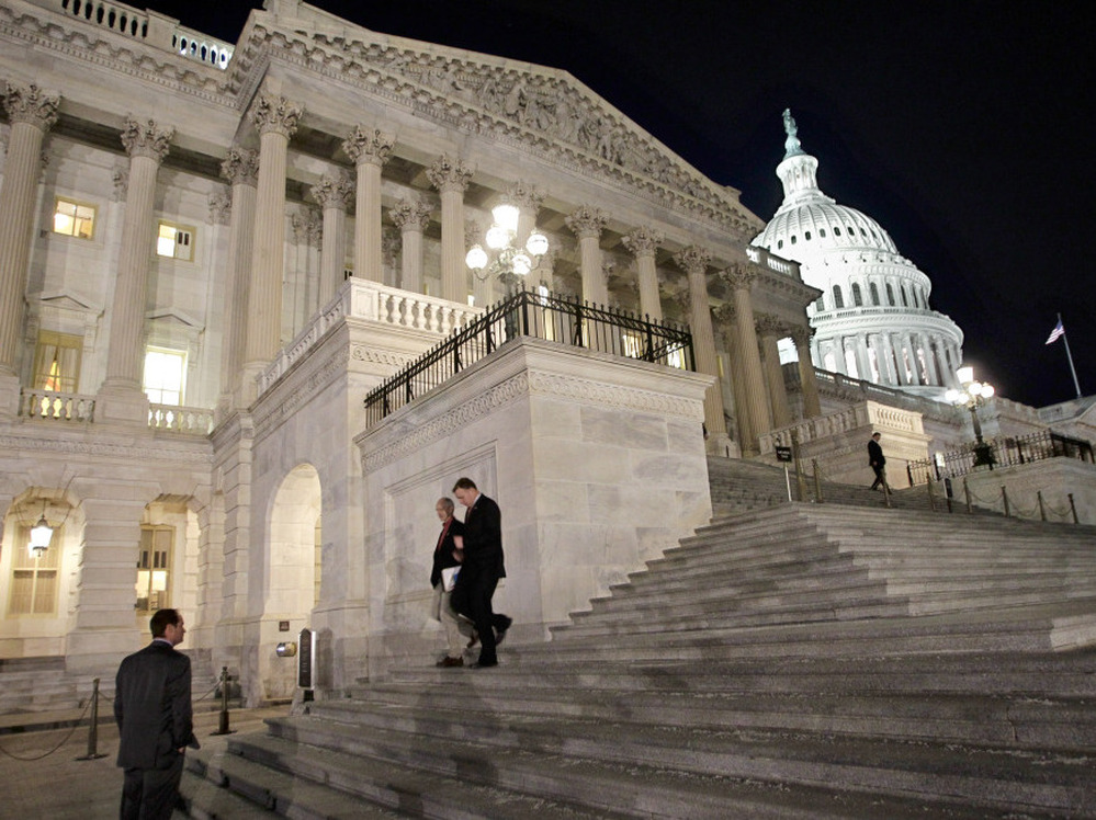 Congressmen walk down the steps of the House of Representatives as they work overnight on a spending bill in February.