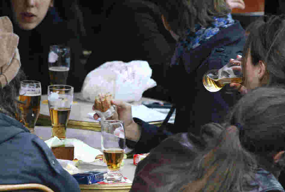 Youths drink beer in a Paris cafe.
