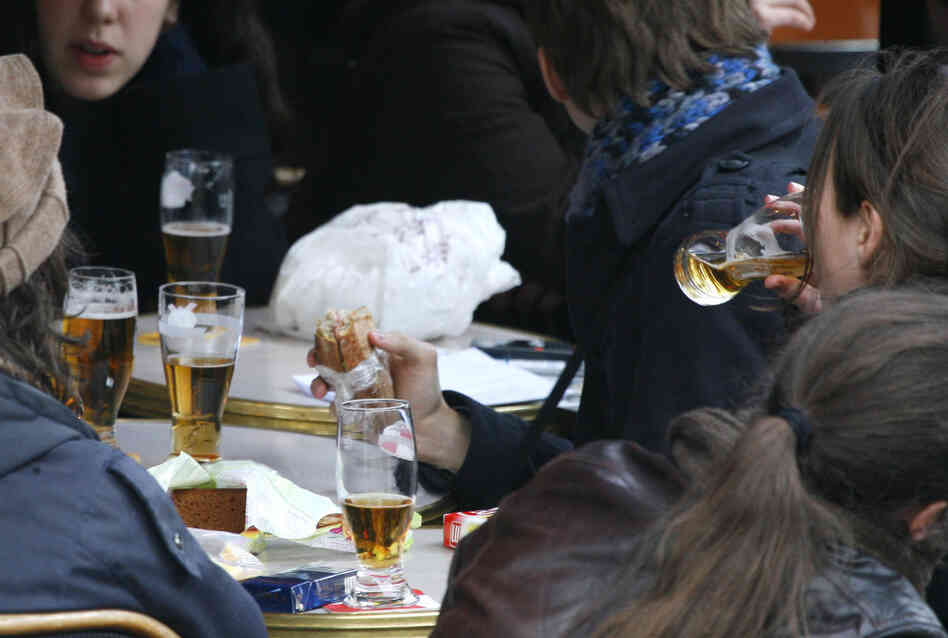 Youths drink beer in a Paris cafe.