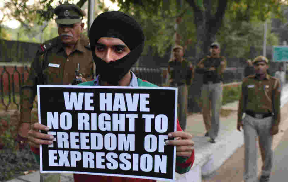 An activist of Bhagat Singh Kranti Sena hold placards and roses outside the residence of Communications and IT Minister Kapil Sibal in New Delhi.