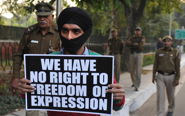 An activist of Bhagat Singh Kranti Sena hold placards and roses outside the residence of Communications and IT Minister Kapil Sibal in New Delhi. An activist of Bhagat Singh Kranti Sena hold placards and roses outside the residence of Communications and IT Minister Kapil Sibal in New Delhi.