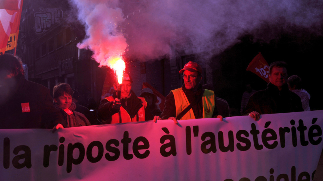 A French man holds a flare during a protest against the government's austerity measures on Tuesday in Lille, northern France. European governments are proposing austerity measures, but critics say there should also be a plan for economic growth.