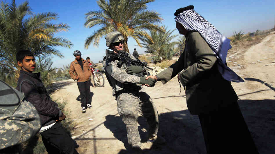U.S. Army Lt. Adam Wilson from Ontario, Calif., shakes hands with Sheik Mahmood Al-Ghizzi, possibly for the last time, on Dec. 5 in Nasiriyah, Iraq. The two men met for a final lunch as the U.S. military prepares to leave Iraq after a nearly nine-year presence. 