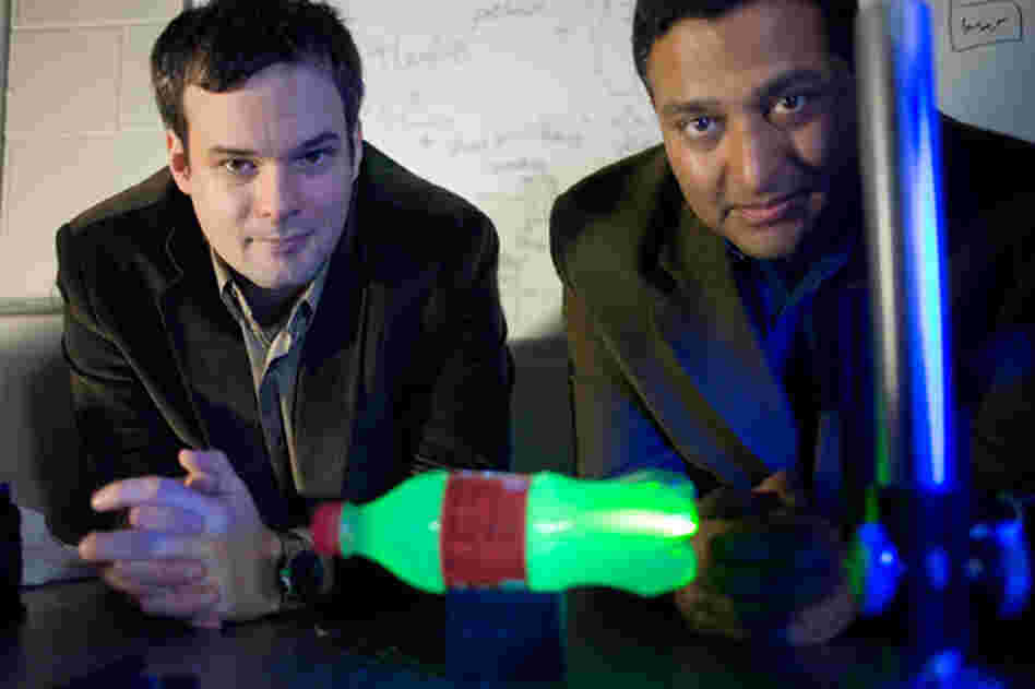 MIT Media Lab postdoc Andreas Velten, left, and Associate Professor Ramesh Raskar. In the foreground is a plastic bottle glowing with laser light. MIT Media Lab postdoc Andreas Velten, left, and Associate Professor Ramesh Raskar. In the foreground is a plastic bottle glowing with laser light.