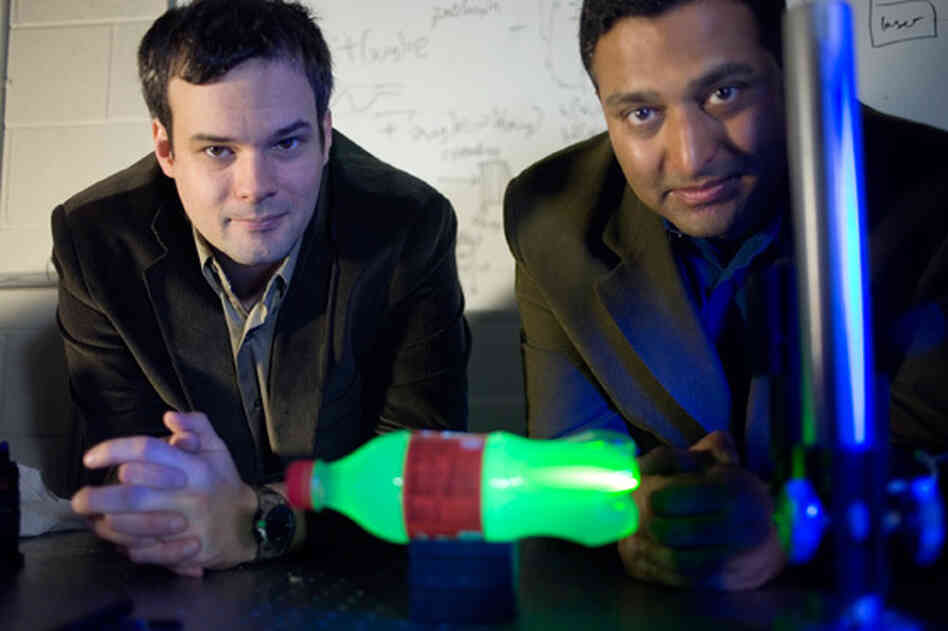 MIT Media Lab postdoc Andreas Velten, left, and Associate Professor Ramesh Raskar. In the foreground is a plastic bottle glowing with laser light. MIT Media Lab postdoc Andreas Velten, left, and Associate Professor Ramesh Raskar. In the foreground is a plastic bottle glowing with laser light.