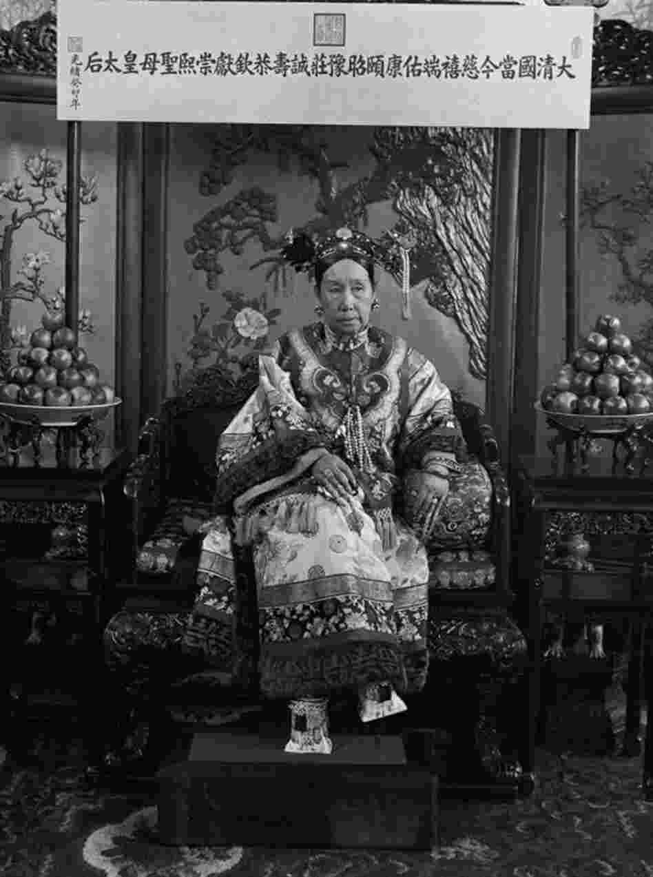 This photograph is one of a series of photos that shows Cixi seated on her throne in front of a banner that declares her full title. Click here to see a close-up of her "horse-hoof" platform shoes.