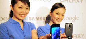 Models hold the new Samsung Galaxy Nexus Android phone during its official launch in Hong Kong in October. The new smartphone runs Google's Android "Ice Cream Sandwich" operating system.
