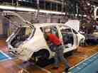 A worker installs components into a Leaf electric vehicle at the company's plant in Kanagawa, Japan. 
