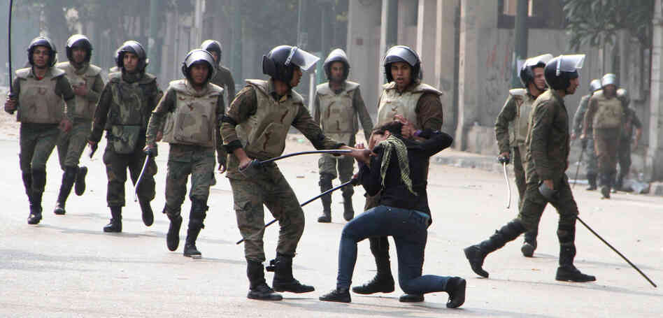 Egyptian army soldiers arrest a woman protester during clashes with military police near Cairo's Tahrir Square. Egyptian army soldiers arrest a woman protester during clashes with military police near Cairo's Tahrir Square.