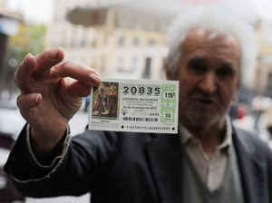 A man holds a Christmas 'El Gordo' lottery ticket he is hoping to sell in November in Madrid, Spain. It's a tradition for many people in Spain to buy tickets for the annual lottery, the largest of the year. A man holds a Christmas 'El Gordo' lottery ticket he is hoping to sell in November in Madrid, Spain. It's a tradition for many people in Spain to buy tickets for the annual lottery, the largest of the year.