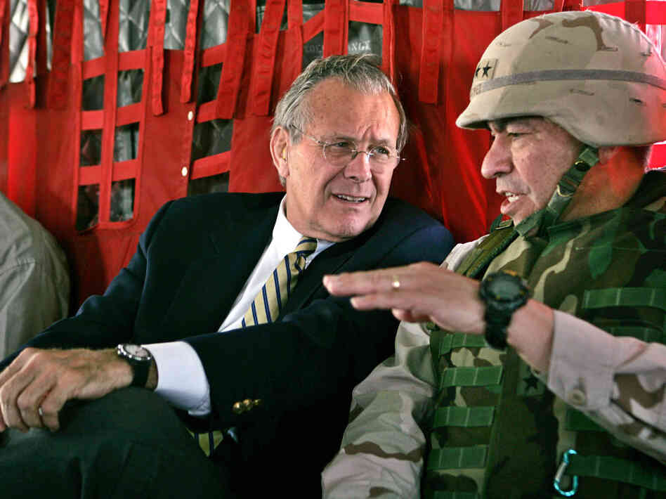 Secretary of Defense Donald Rumsfeld, left, listens to Gen. Ricardo Sanchez, Commander of the coalition forces in Iraq, on a flight from Kuwait City to Baghdad in 2004.