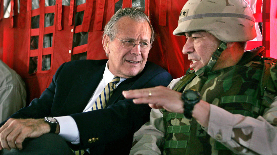 Secretary of Defense Donald Rumsfeld, left, listens to Gen. Ricardo Sanchez, Commander of the coalition forces in Iraq, on a flight from Kuwait City to Baghdad in 2004.