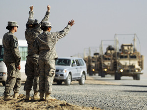 Soldiers wave to the last American military convoy to depart Iraq after it crosses over the border into Kuwait on Sunday. Soldiers wave to the last American military convoy to depart Iraq after it crosses over the border into Kuwait on Sunday.