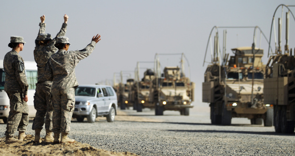 Soldiers wave to the last American military convoy to depart Iraq after it crosses over the border into Kuwait on Sunday.