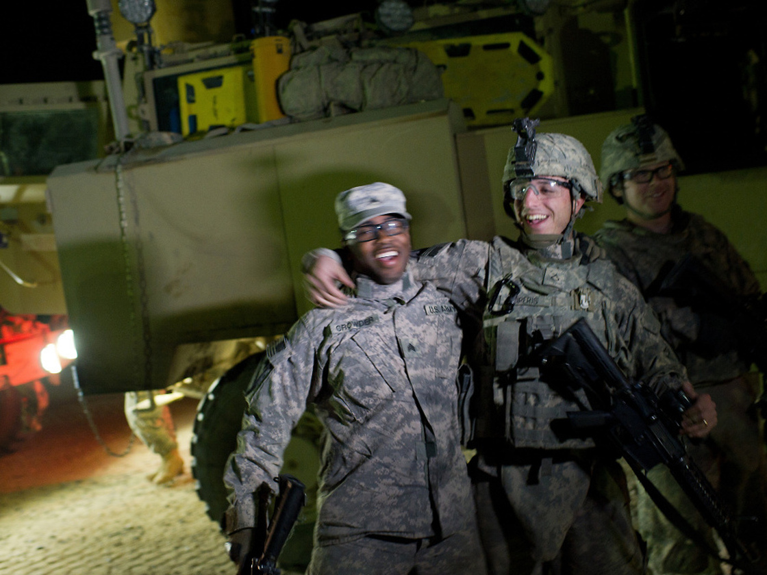 U.S. soldiers celebrate as the first vehicles of the last U.S. military convoy carrying troops out of Iraq passes through the K-Crossing at Iraq's border with Kuwait early on Sunday morning. 