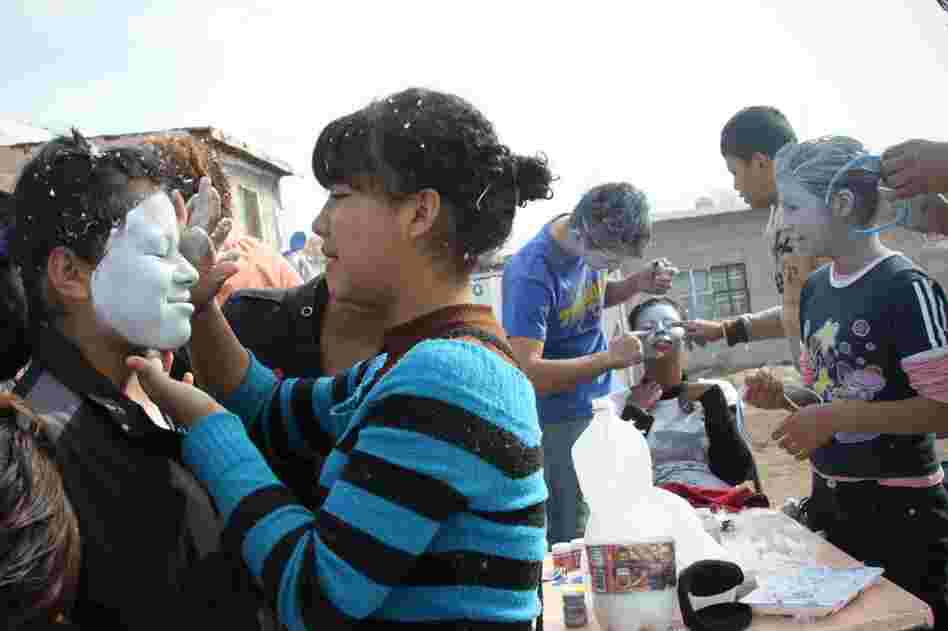 In the Tierra Nueva neighborhood of Ciudad Juarez, youth church members get ready for their weekly outing as messenger angels by painting and applying glitter to their faces. Their wings are made with goose down, and their robes are old curtains.