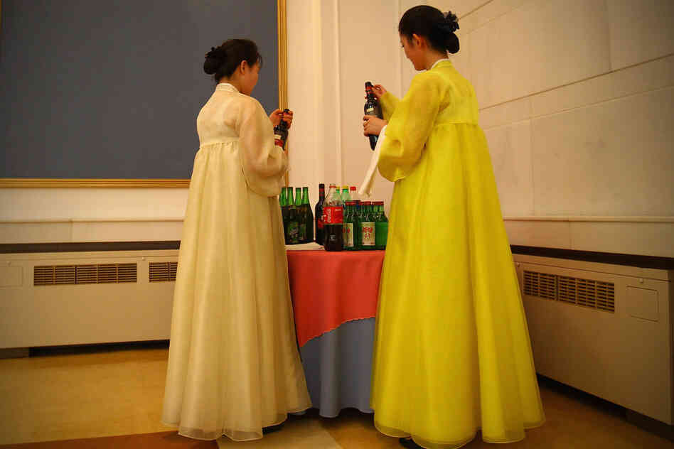 Two North Korean waitresses open bottles of wine during an official reception in the capital, Pyongyang.
