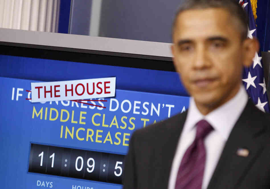 President Obama speaks in the White House's Brady Briefing Room on Tuesday. Behind the president, a ticking clock counts down the time until taxes will go up if Congress can't reach an extension deal on payroll tax cuts.
