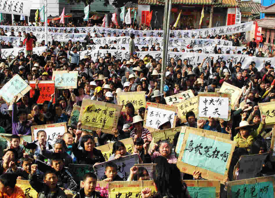 In a rare mass protest, thousands of people from the besieged village of Wukan, China, gather to demonstrate against what they say are illegal land seizures by the government. The villagers accuse local officials of selling 6.5 square miles of their land to boost government revenues. In a rare mass protest, thousands of people from the besieged village of Wukan, China, gather to demonstrate against what they say are illegal land seizures by the government. The villagers accuse local officials of selling 6.5 square miles of their land to boost government revenues.