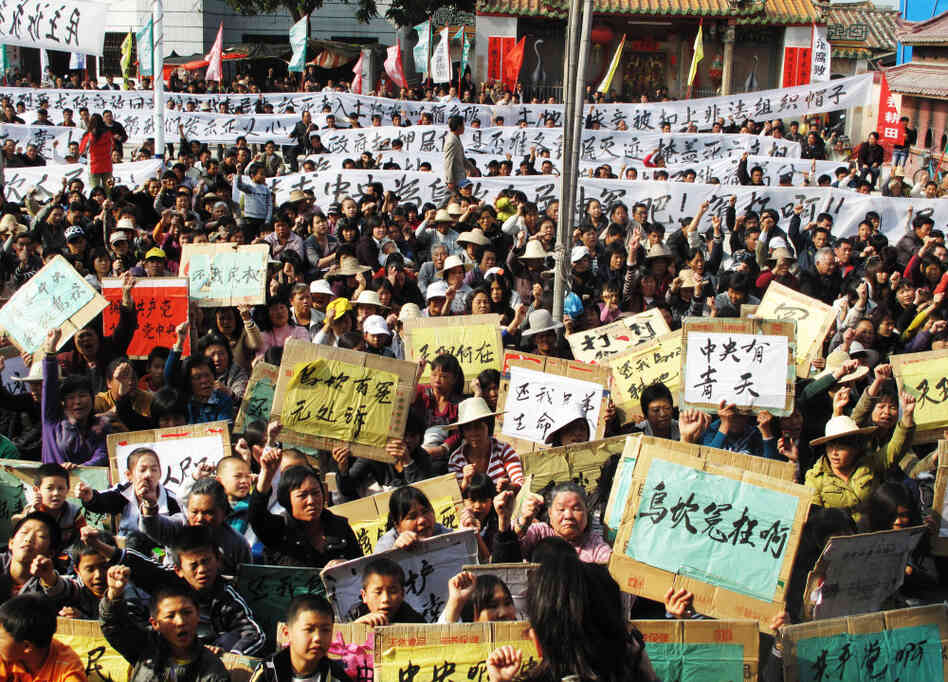 In a rare mass protest, thousands of people from the besieged village of Wukan, China, gather to demonstrate against what they say are illegal land seizures by the government. The villagers accuse local officials of selling 6.5 square miles of their land to boost government revenues. In a rare mass protest, thousands of people from the besieged village of Wukan, China, gather to demonstrate against what they say are illegal land seizures by the government. The villagers accuse local officials of selling 6.5 square miles of their land to boost government revenues.