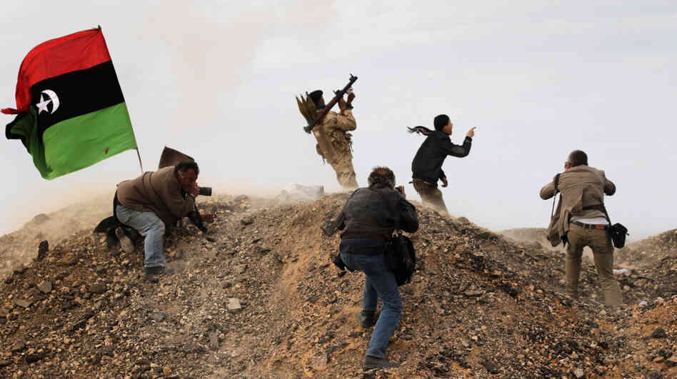 Photojournalists, including New York Times staff photographer Tyler Hicks, photograph Libyan rebels on March 10 in Ras Lanuf, Libya. Hicks and three other Times journalists — Stephen Farrell, Lynsey Addario and Anthony Shadid — were released March 21 after being held captive by Libyan forces. 